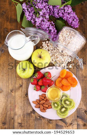 Healthy cereal with milk and fruits on wooden table