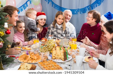 Large happy russian family talking animatedly during Christmas dinner.