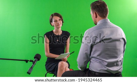 Young female presenter with pixelated and hidden face in tv studio interviewing