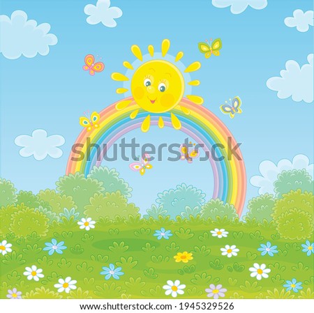 Friendly smiling sun with a colorful rainbow and butterflies merrily flittering over a green field with flowers and green bushes after warm summer rain, vector cartoon illustration