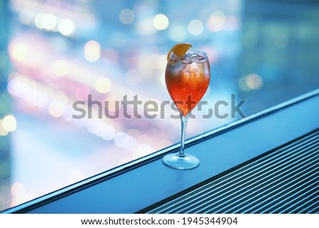 Cocktail glasses on the windowsill by the glass of a tall building