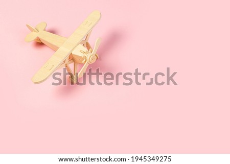 wooden model of a passenger plane with on a pink background. tourism and travel 