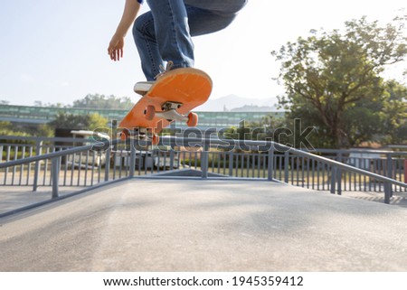 Asian woman skateboarder skateboarding at skatepark