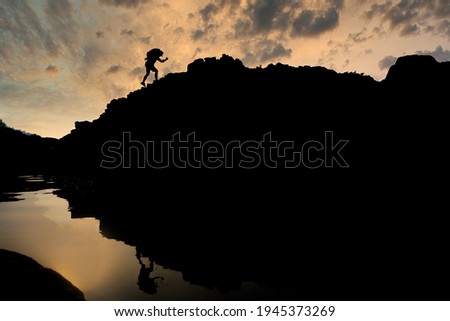 Young male tourists climbing mountains Ideas for personal development and goals in the life of a climber with a backpack. Royalty-Free Stock Photo #1945373269