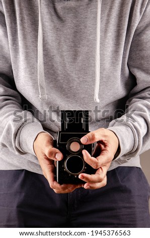 A man is about to calculate the exposure and calculate shutter speed and aperture to photograph with a beautiful 6x6 medium format analog camera of Soviet origin