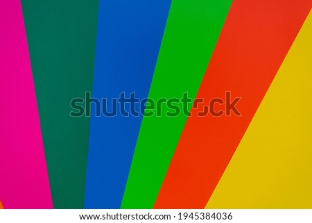 Colorful paper background top view with copy space. Yellow, orange, green, blue, pink, red paper.