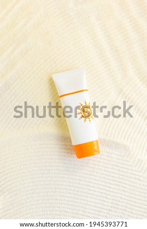 white cosmetic tube with sunscreen cream  on sand textured background. Cosmetic products  with spf. UV protection concept. Copy space