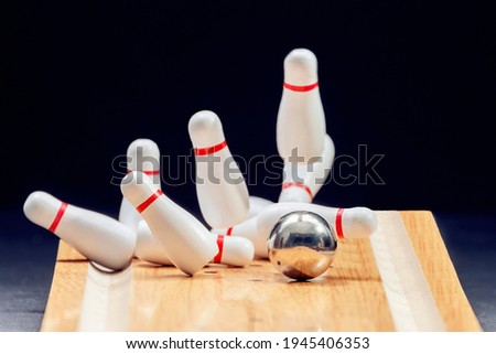 Bowling. Bowling ball knocks down pins on bowling lane . Black background. Copy space. Space for text