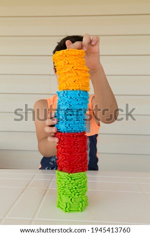 The Child playing colorful shapes games on the table for kids activities.