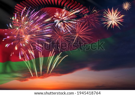 Holiday night sky with fireworks and flag of Malawi for Independence day