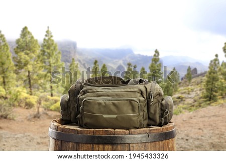 Spring trip time and green bag on wooden old barrel 