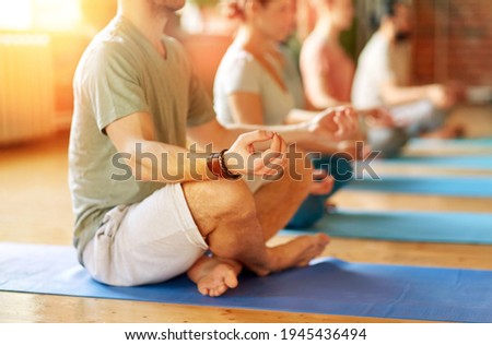 fitness, yoga and healthy lifestyle concept - group of people meditating in lotus pose at studio Royalty-Free Stock Photo #1945436494