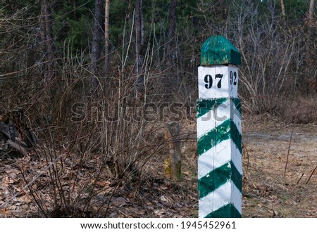 Quarter pillar in the forest. A pillar for a landmark in the forest. Forestry post.
