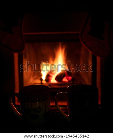 two mugs with fireplace with fire in the background