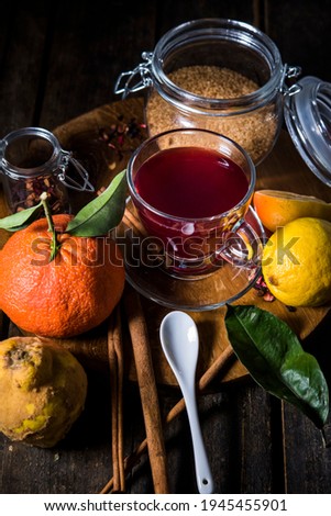 cup of fruit tea on a wooden table. red tea together with its ingredients seen from above