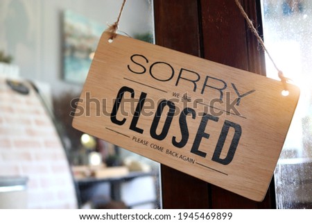 Wooden sign board that says ‘closed’ on cafe or restaurant hang on door at entrance.