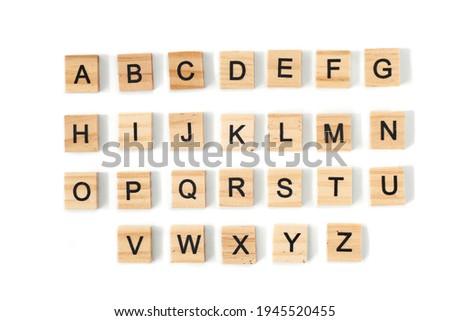 Top view of english alphabet made of square wooden tiles with the English alphabet scattered on a white background with space for text. The concept of thinking development, grammar. Royalty-Free Stock Photo #1945520455