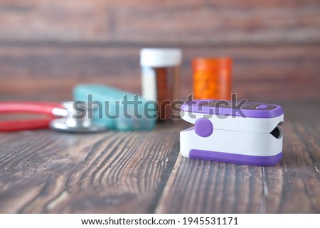  pulse oximeter and medical container on table 