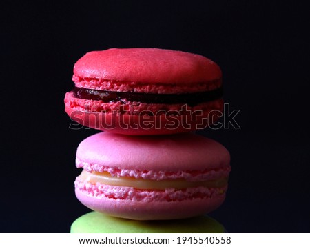 Close up red, pink and green macarons or macaroons on the black background.