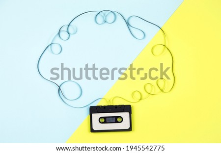 Analogue cassette tape on pastel blue and green diagonal background, 80s retro frame, lot of empty copy space. 