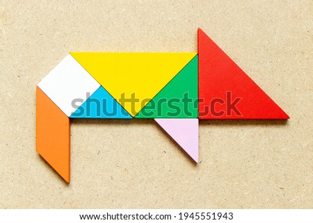 Color tangram puzzle in pig or hog shape on wood background