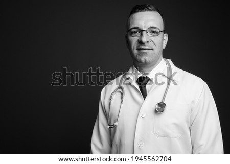 Man doctor wearing eyeglasses against gray background