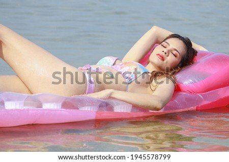 Beautiful Asian woman are happy and relaxed on a summer vacation at the beautiful beaches of Thailand.