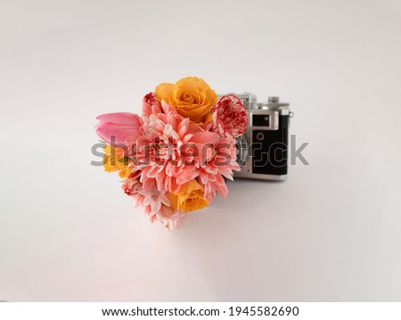 Retro camera with colorful spring flowers against white background. Creative concept. Minimal nature concept.