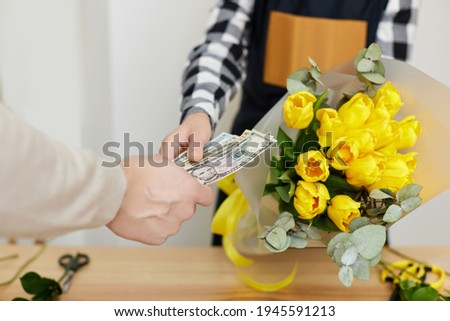 Woman florist selling flowers to a man