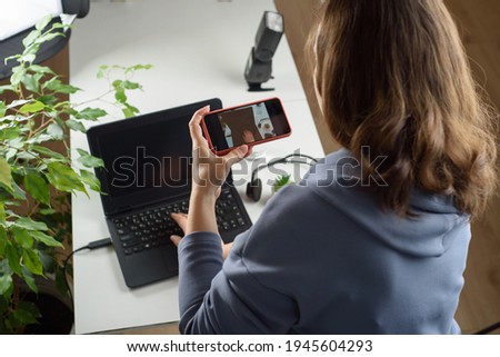 A woman photographer takes photo of a workplace on the phone. Freelance