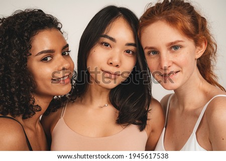 Photo of optimistic cute women, multiracial friends, wear underwear. Feminist females smile and show their love. Concept natural beauty and girl power