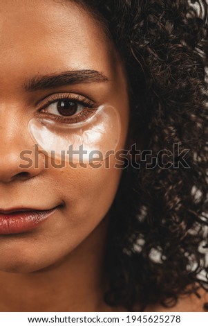 Close up photo of face attractive black woman with patches under eye. Isolated over white background. Natural beauty and health
