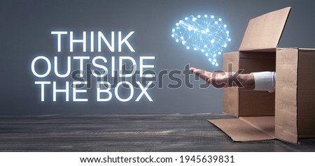 Male hand holding a human brain coming out from a cardboard box. Think Out Of The Box
