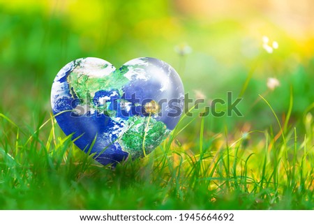Earth in Heart shape on green grass and flowers on sunlight, Love and Save the World for the Next Generation concept, Earth day concept, Elements of this image furnished by NASA Royalty-Free Stock Photo #1945664692