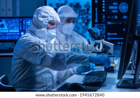 Professional team of scientists is working on a vaccine in a modern scientific research laboratory. Genetic engineer workplace. Future technology and science concept.