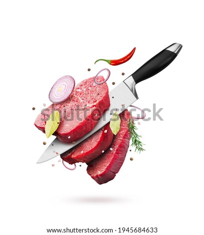Pieces of raw beef steaks with knife, spice and pepper, isolated on white background