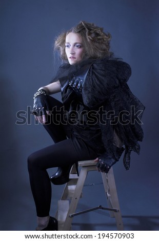 Fashion. Young lady in black and with artistic hairstyle.