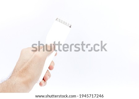 Hand holding white Cordless hair clipper isolated on white background