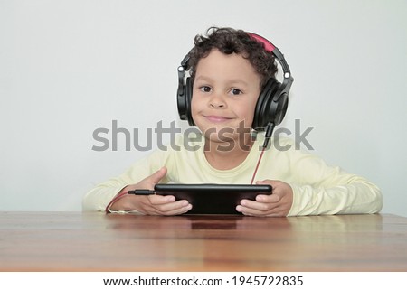 boy with headphones and tablet enjoying music on white background stock photo 