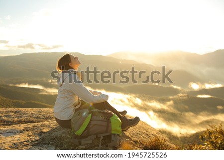 Happy trekker breathing fresh air in the top of a mountain at sunrise Royalty-Free Stock Photo #1945725526