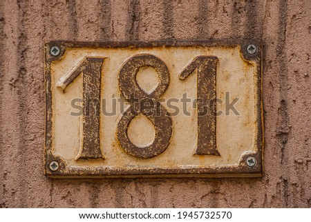 Old retro weathered cast iron plate with number 181 closeup