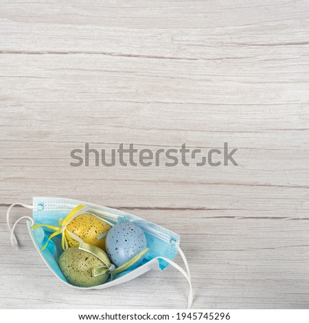 , Colorful eggs in a medical mask HV. time of coronavirus covid19. Health care, relaxation, the mask remains safe. Spring season. Happy Easter banner light background.