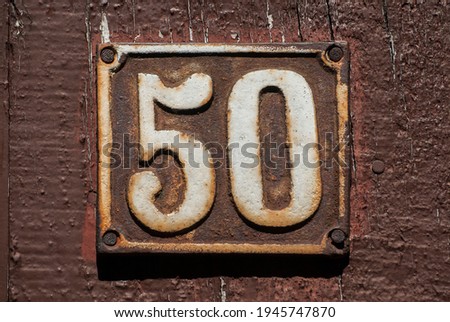 Old retro weathered cast iron plate with number 50 closeup