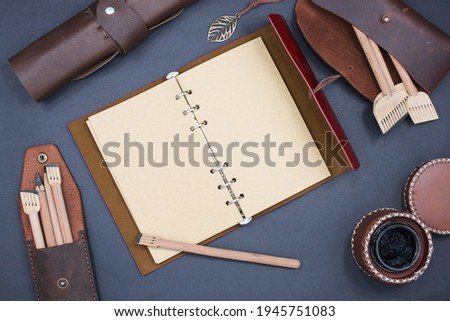 calligraphy mockup, Top view of blank Notebook page, calligraphy pens, genuine leather pencil case and leather inkwell on blank Notebook with space for Your own writing