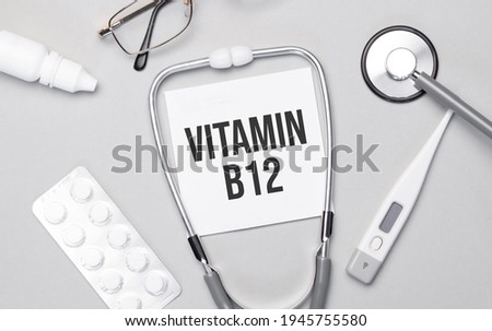 In the notebook is the text VITAMIN B12, stethoscope, pills, and glasses.
