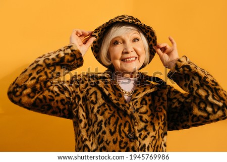 Woman wearing total leopard look flirtatiously adjusting his hat