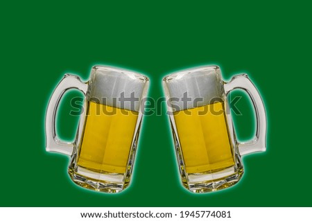 Two mugs with beer on a green background 