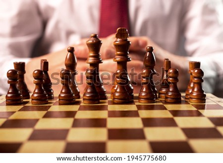 Business start up and control concept. Male hands and chess board under control of boss.