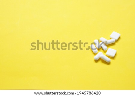 selective focus at White 500mg paracetamol tablets are poured on yellow paper and leave space to edit the text on the right.