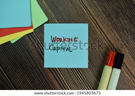 Working Capital write on sticky notes isolated on Wooden Table.